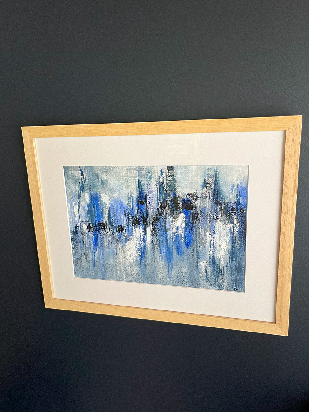 Watercolour Abstract called Drift hanged on a dark blue wall