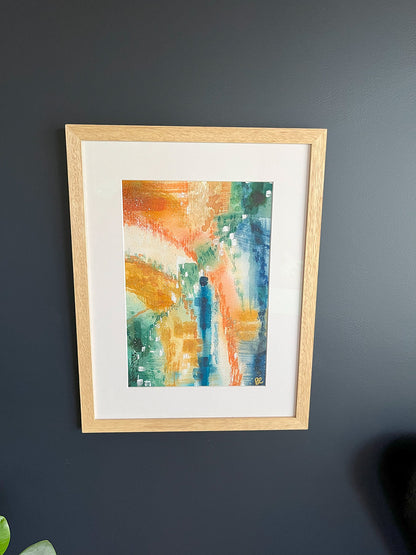 Framed Watercolour Abstract called Yearning hanged on a dark blue wall with plant