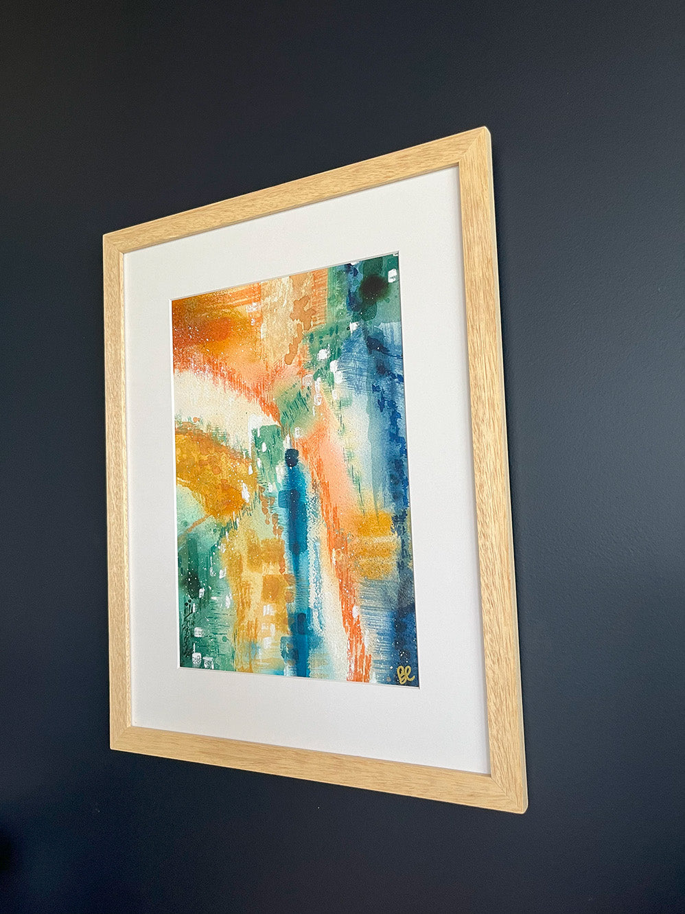 Framed Watercolour Abstract called Yearning hanged on a dark blue wall